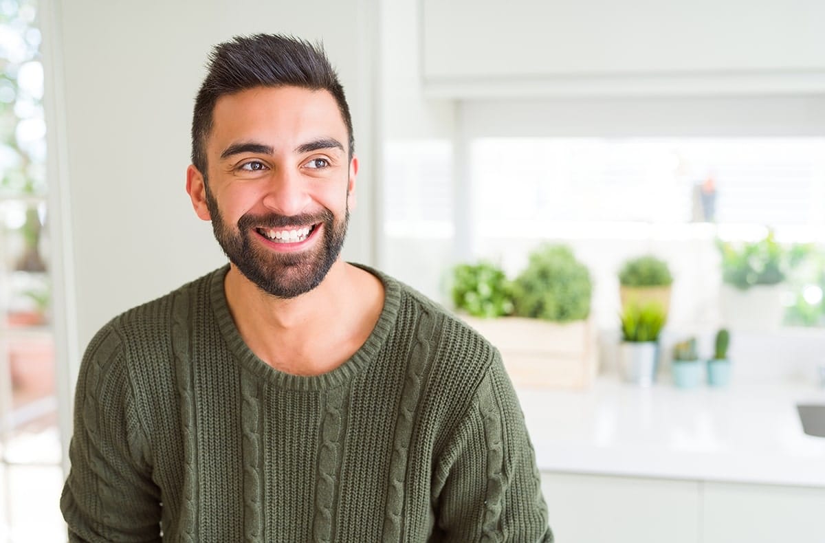 EMG guided TMJ eval banner Young man in green shirt with beard smiling